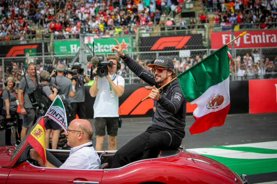 FERNANDO ALONSO EN EL DESFILE DE PILOTOS DE 2018, ONDEANDO UNA BANDERA DE MÉXICO
